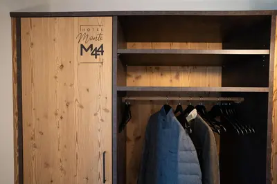 a closet with a wooden door and a clothes rack at Hotel Monte44 in Selva di Val Gardena