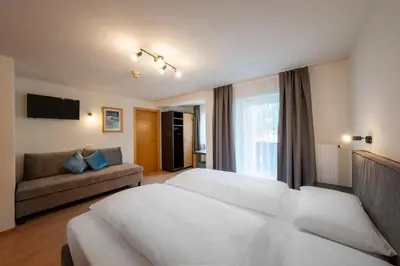a hotel room with a bed and a couch at Hotel Monte44 in Selva di Val Gardena