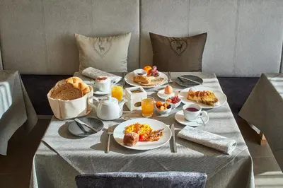 a table with breakfast foods and coffee on it at Hotel Tabladel in Colfosco