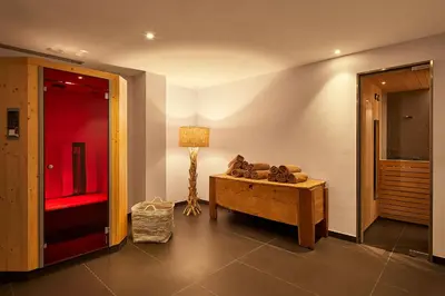 a living room with a couch and a lamp at Hotel Tabladel in Colfosco