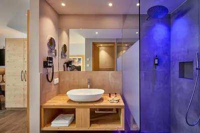 a bathroom with a sink and a shower at Hotel Tabladel in Colfosco