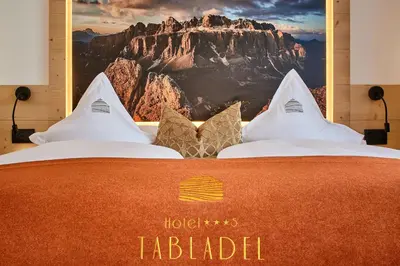 a hotel indedia sign on a bed in a room at Hotel Tabladel in Colfosco
