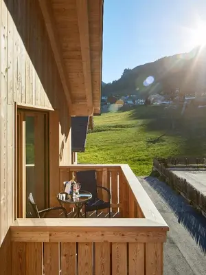a balcony with a table and chairs on a house at Hotel Tabladel in Colfosco