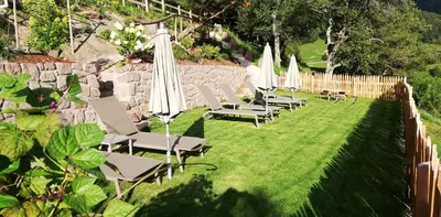 a row of chairs with umbrellas on a lawn at Ritschhof in Laion