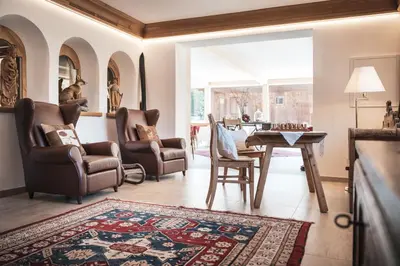 a living room with two chairs and a table at Hotel Chalet Corso in San Vigilio Di Marebbe