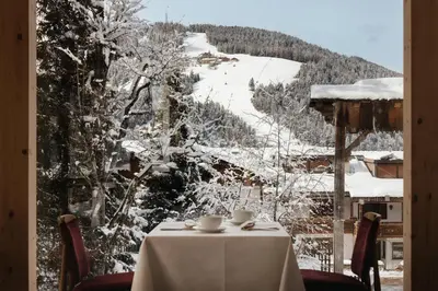 a table with a view of a snow covered mountain at Hotel Chalet Corso in San Vigilio Di Marebbe