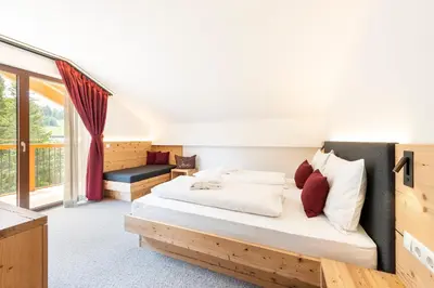 a bedroom with a bed and a large window at Hotel Seelaus in Alpe di Siusi