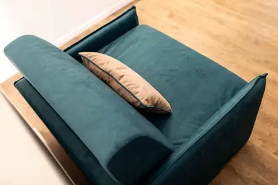 a green couch with a pillow on the floor at Stay COOPER l Guesthouse zum Löwen in Merano