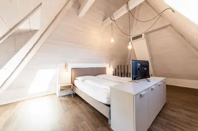 a bedroom with a large bed in an attic at Stay COOPER l Guesthouse zum Löwen in Merano
