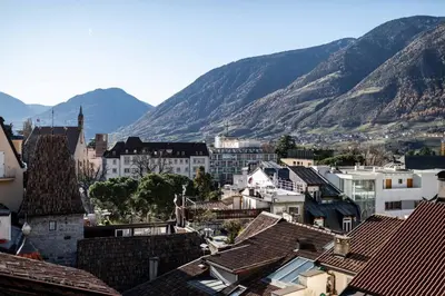 a view of a city with mountains in the background at Stay COOPER l Guesthouse zum Löwen in Merano