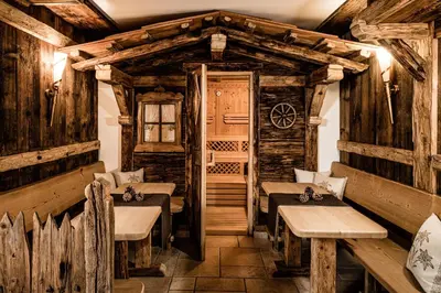 a restaurant with wooden walls and tables and a door at Giardin Boutique Hotel B&B in Selva di Val Gardena