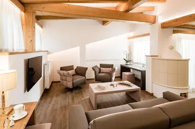a living room with a couch and a table at Giardin Boutique Hotel B&B in Selva di Val Gardena