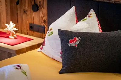 a bedroom with a bed with pillows on it at Chalets Almdorf Haidenberg in Brunico