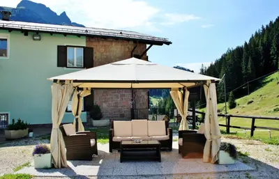 a gazebo with chairs and a table at Santa Maria ad Nives in Canazei