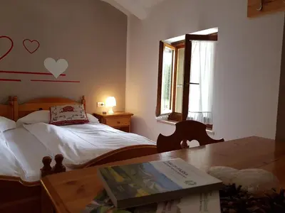 a bedroom with a bed and a desk with a table at Santa Maria ad Nives in Canazei