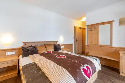 a bedroom with a large bed in a room at Hotel Lindnerhof in San Lorenzo di Sebato