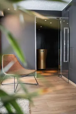 an empty room with a chair and a hallway at Hotel Lindnerhof in San Lorenzo di Sebato