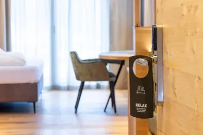 a room with a table and a door with a sign on it at Hotel Lindnerhof in San Lorenzo di Sebato