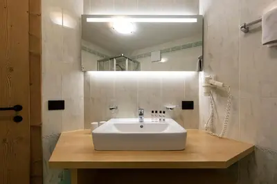 a bathroom with a white sink and a mirror at Apartments & Garnì Pre Da Nai in La Villa