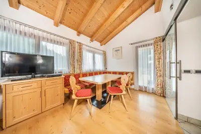 a dining room with a table and chairs and a television at Apartments & Garnì Pre Da Nai in La Villa