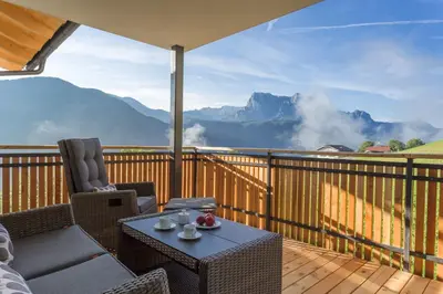 a patio with a table and chairs on a balcony with mountains at Tschörlerhof in Barbiano