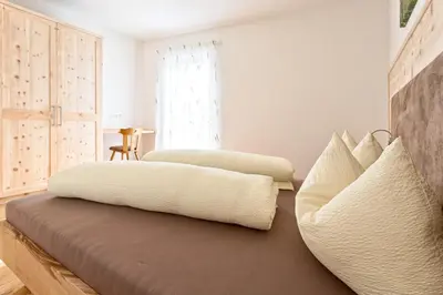 a bedroom with two beds and a couch at Tschörlerhof in Barbiano