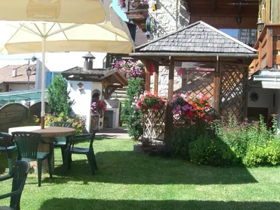 a garden with a table and a gazebo at Garni Val Udai in Mazzin
