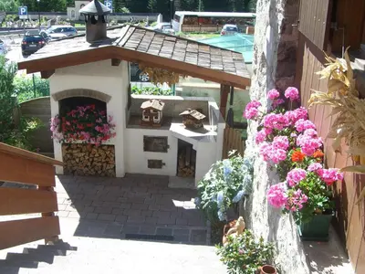 a model of a house with a fireplace and flowers at Garni Val Udai in Mazzin