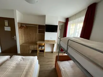a room with two bunk beds and a desk at Garni Val Udai in Mazzin