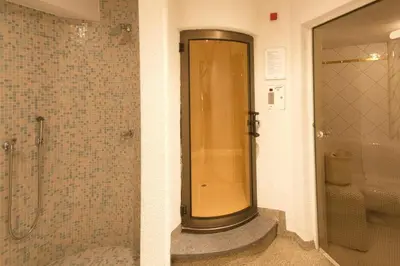 a shower in a bathroom with a glass door at Hotel Vallechiara in Moena