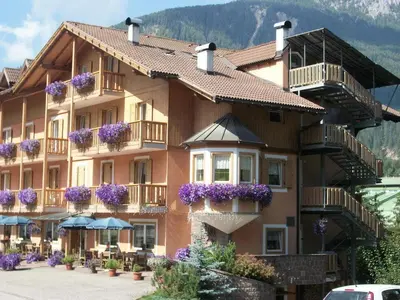 a large building with purple flowers on the balconies at Hotel Vallechiara in Moena