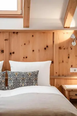 a bedroom with a bed and a wooden wall at Christlrumerhof in Brunico