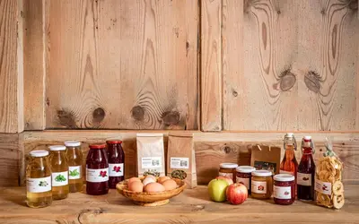 a bunch of bottles and jars of food and apples at Christlrumerhof in Brunico