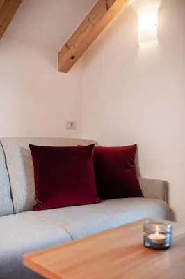 a living room with a couch with a red pillow at Christlrumerhof in Brunico
