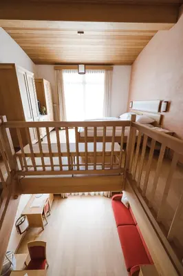 a room with a loft bed with a red rug at Hotel Monte Sella in San Vigilio Di Marebbe