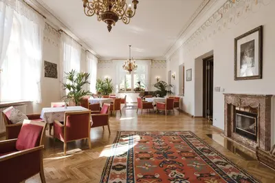 a dining room with tables and chairs and a fireplace at Hotel Monte Sella in San Vigilio Di Marebbe