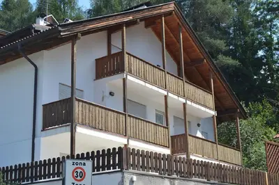 a house with wooden balconies on the side of it at Max 's Siusi Apartament in Siusi