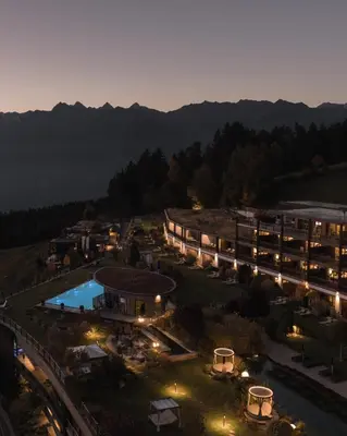 an aerial view of a resort with a pool at night at Chalet Mirabell in Avelengo