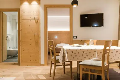 a dining room with a table and a television at Residence Chalet Pinis in Corvara in Badia