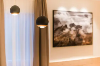 two lights hanging on a wall with a picture at Residence Chalet Pinis in Corvara in Badia