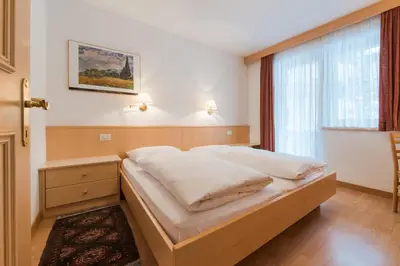 a bed in a room with a window at Residence Chalet Pinis in Corvara in Badia