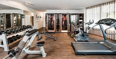 a gym with several treadmills and elliptical machines at Hotel Saltauserhof in Saltusio