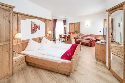 a bedroom with a bed and a living room at Hotel Saltauserhof in Saltusio