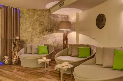 a living room with two chairs and green pillows at Hotel Saltauserhof in Saltusio