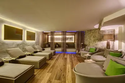 a living room with couches and green pillows at Hotel Saltauserhof in Saltusio
