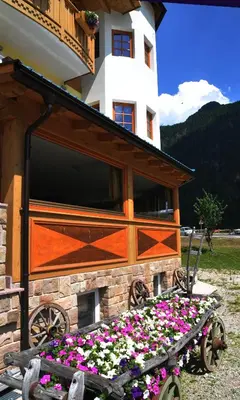 a flower bed in front of a building with flowers at Hotel Ciamol in Mazzin