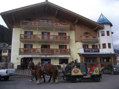 a horse drawn carriage in front of a hotel at Hotel Ciamol in Mazzin