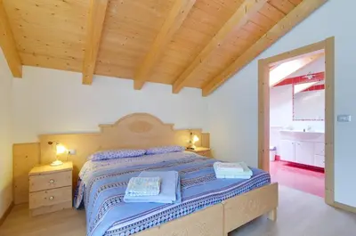 a bedroom with a bed and a wooden ceiling at Agritur Belsogno B&B in Brez
