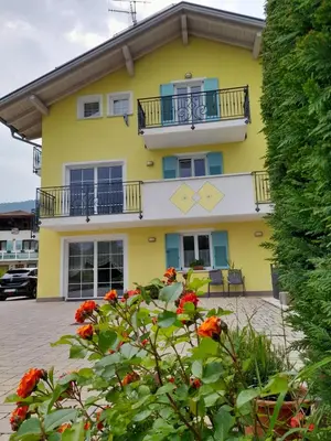a yellow house with flowers in front of it at Agritur Belsogno B&B in Brez