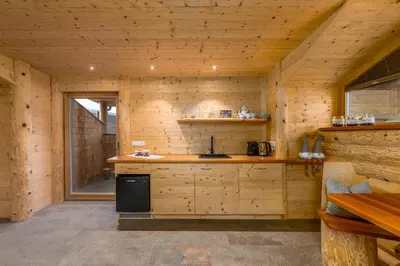 a kitchen in a wooden cabin with a stove at Mesnerhof my Paradise in Fiè
